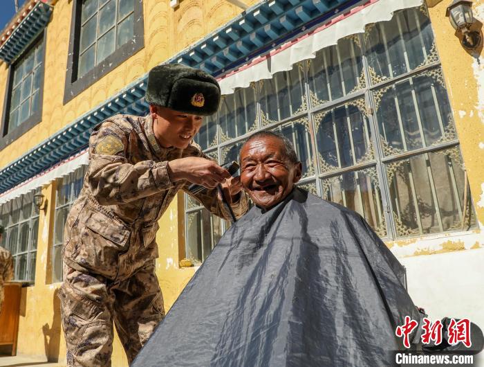 圖為阿里軍分區(qū)某邊防團(tuán)官兵為駐地群眾理發(fā)迎藏歷新年?！〉┰鰝愔?攝