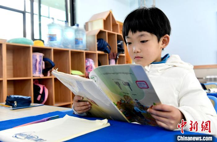 3月14日，西藏拉薩市第一小學(xué)一年級六班學(xué)生丁增樂吉在閱讀藏語課本。　李林 攝