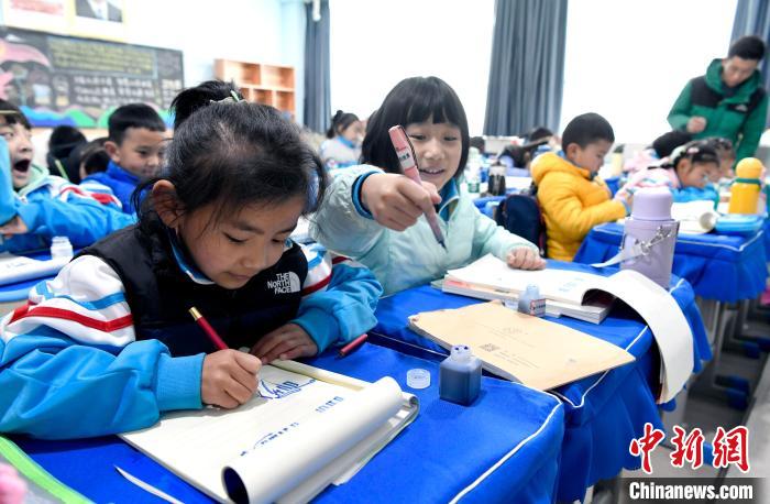 3月14日，西藏拉薩市第一小學(xué)一年級六班學(xué)生白瑪朗珍(圖左)在藏語文課上書寫藏文?！±盍?攝