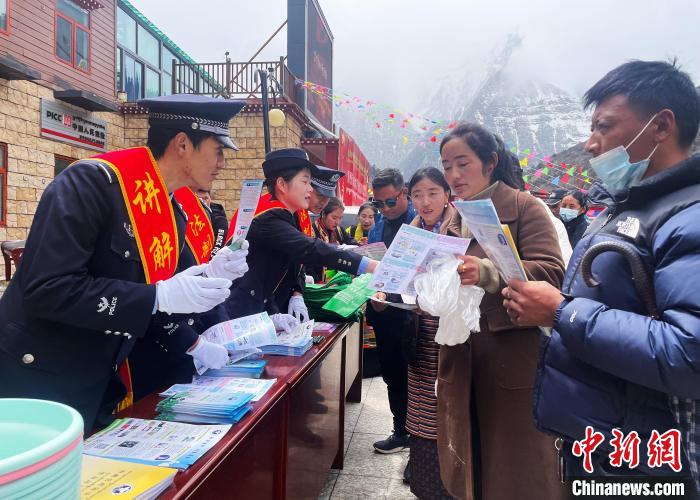 圖為山南玉麥邊境派出所民警為轄區(qū)群眾發(fā)放法律知識宣傳單?！＄婗?　攝