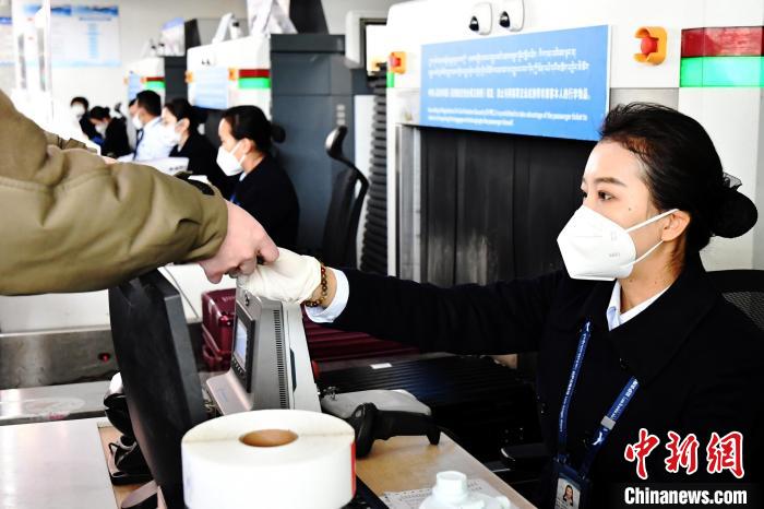 圖為機(jī)場工作人員為旅客辦理行李托運(yùn)?！≈芎?攝