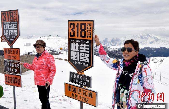 圖為5月14日，西藏林芝色季拉山觀景臺，游客與南迦巴瓦峰合影?！±盍?攝